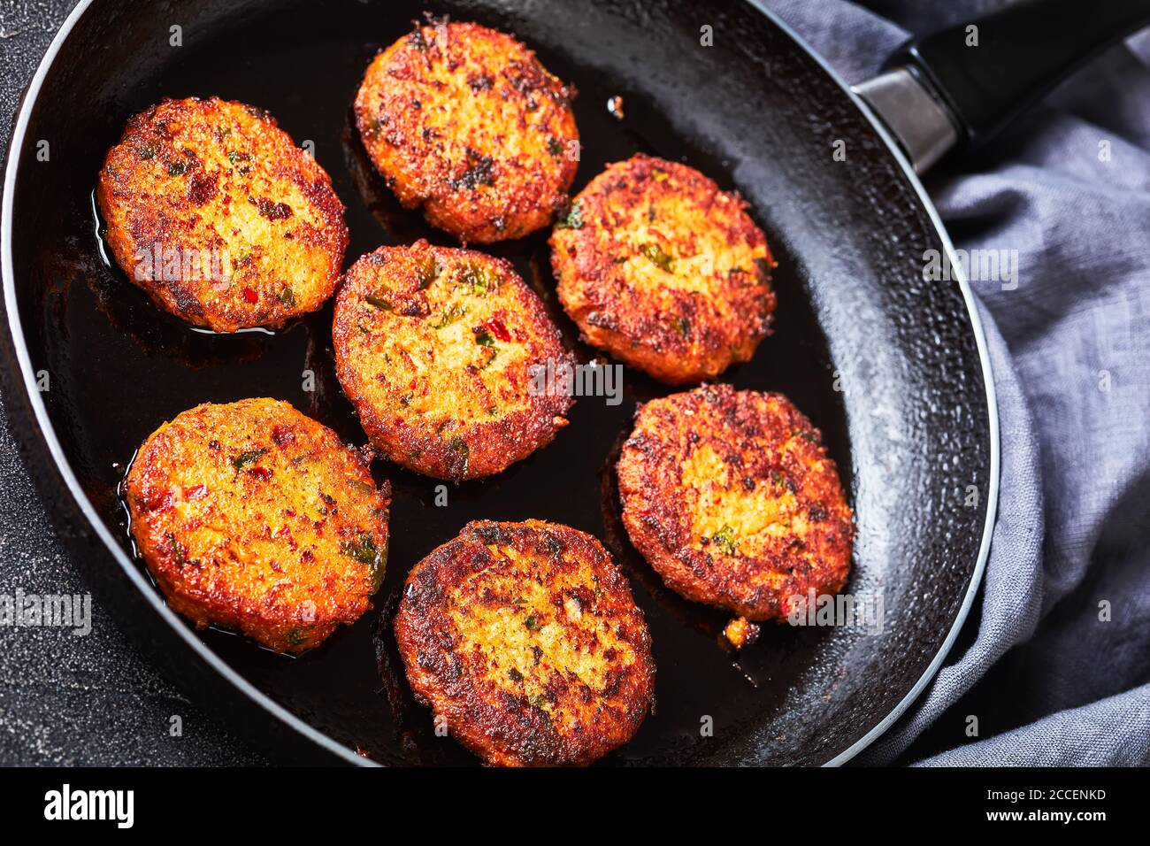 Gebratene thai-Fischkuchen in einer Pfanne auf einem Betontisch zubereitet, horizontale Ansicht von oben, Nahaufnahme Stockfoto