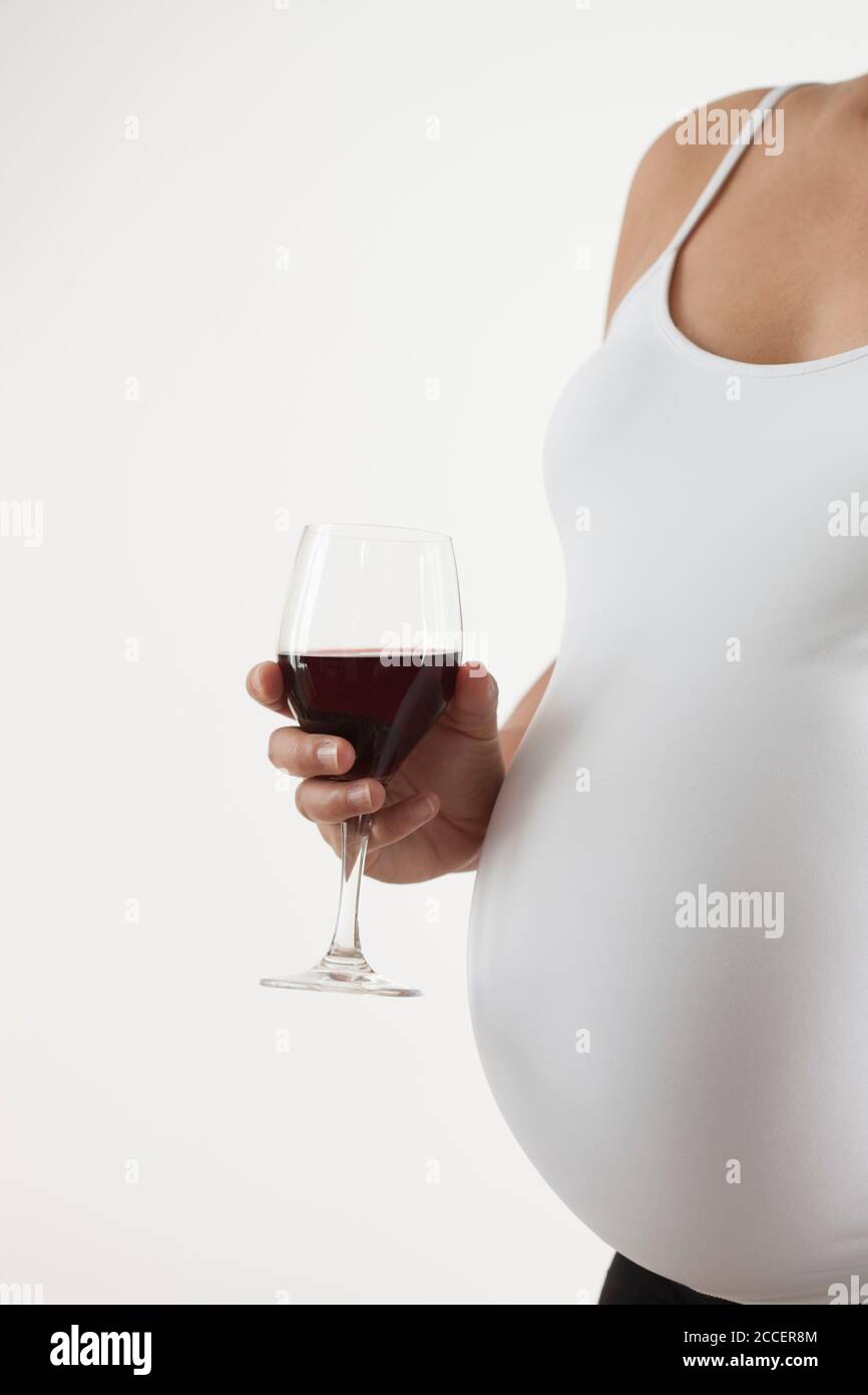 Schwangere Frau mit einem Glas Rotwein Stockfoto