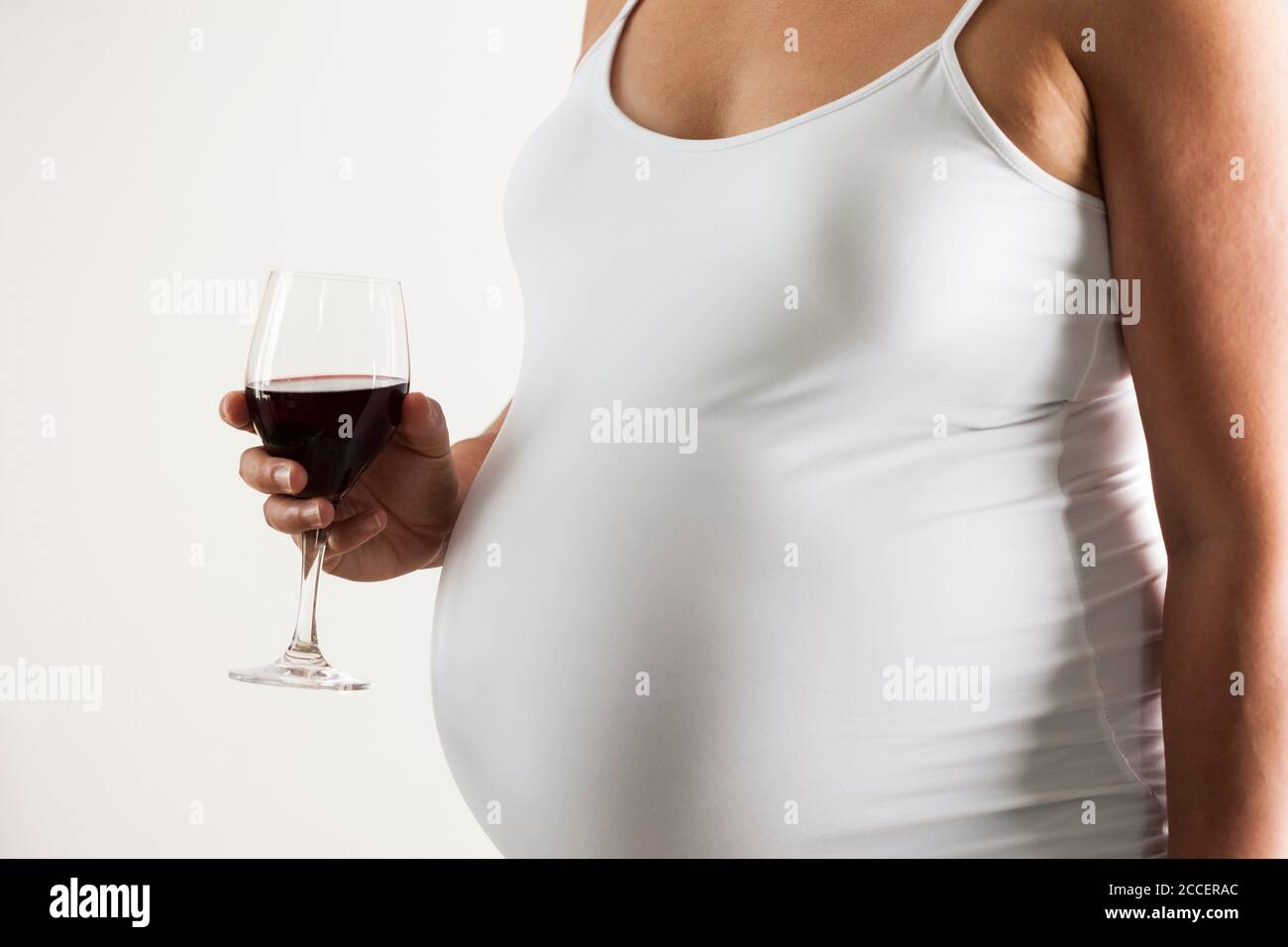 Schwangere Frau mit einem Glas Rotwein Stockfoto