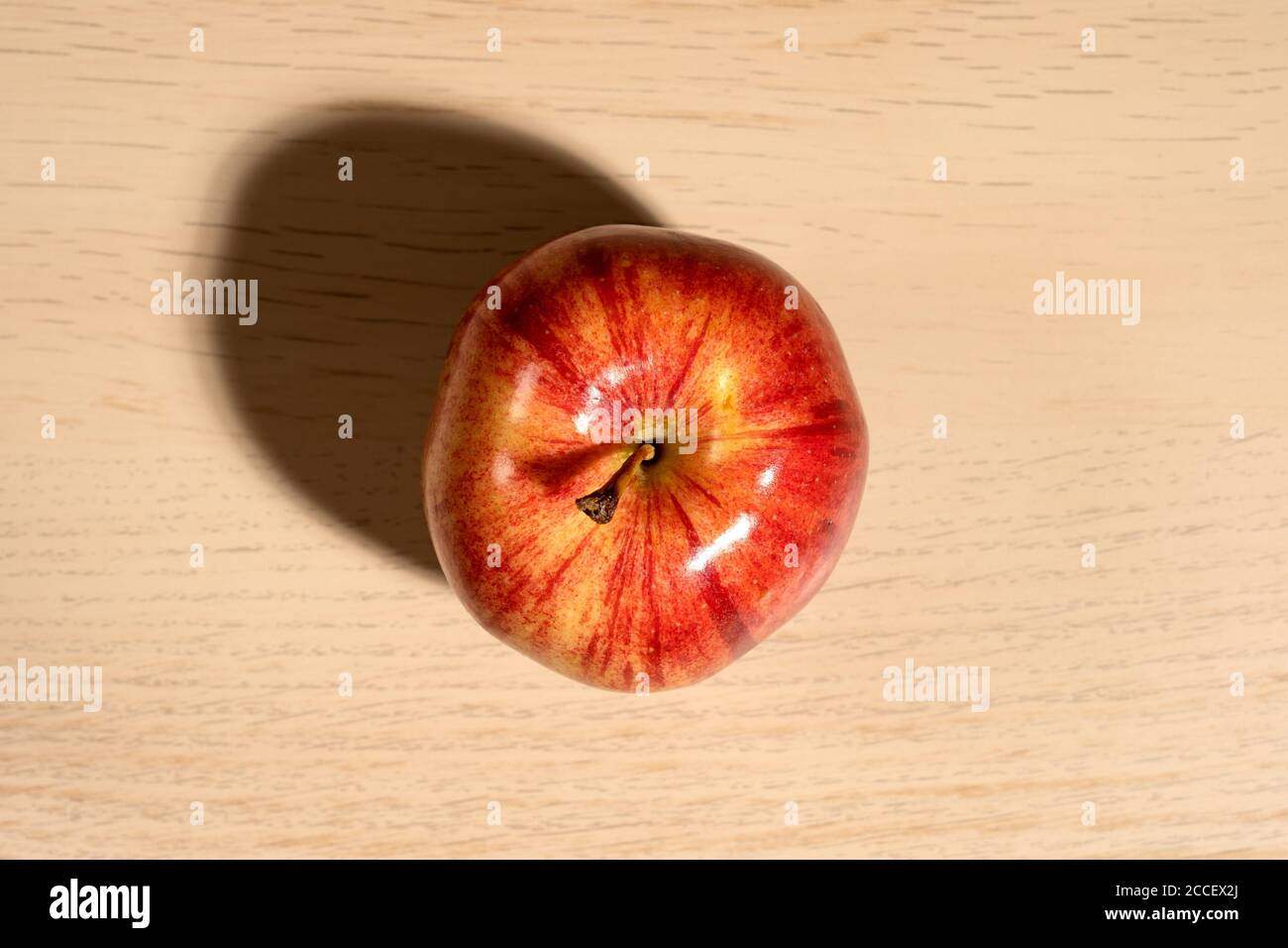 Ein GalaApple auf einem Tisch mit Schatten, von oben aufgenommen. Stockfoto