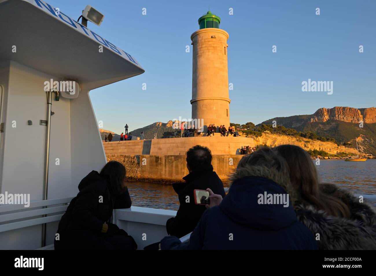 Touristen, die von einer Bootstour entlang des spektakulären Calanques National Park bei Sonnenuntergang zurückkehren, Cassis FR Stockfoto