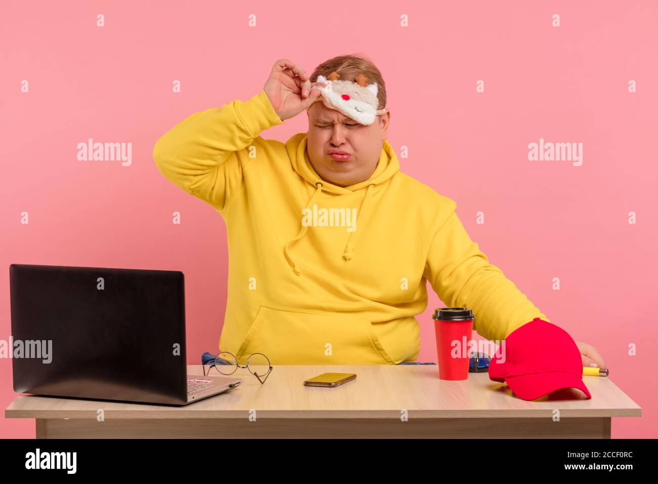 Fleissiger Schlafriger Mann Mit Gelbem Hoodie Arbeitete Die Ganze Nacht Wachte Gerade Auf Nahm Die Schlafmaske Vom Kopf Sass Am Schreibtisch Mit Kaffee Vor Dem Revers Stockfotografie Alamy