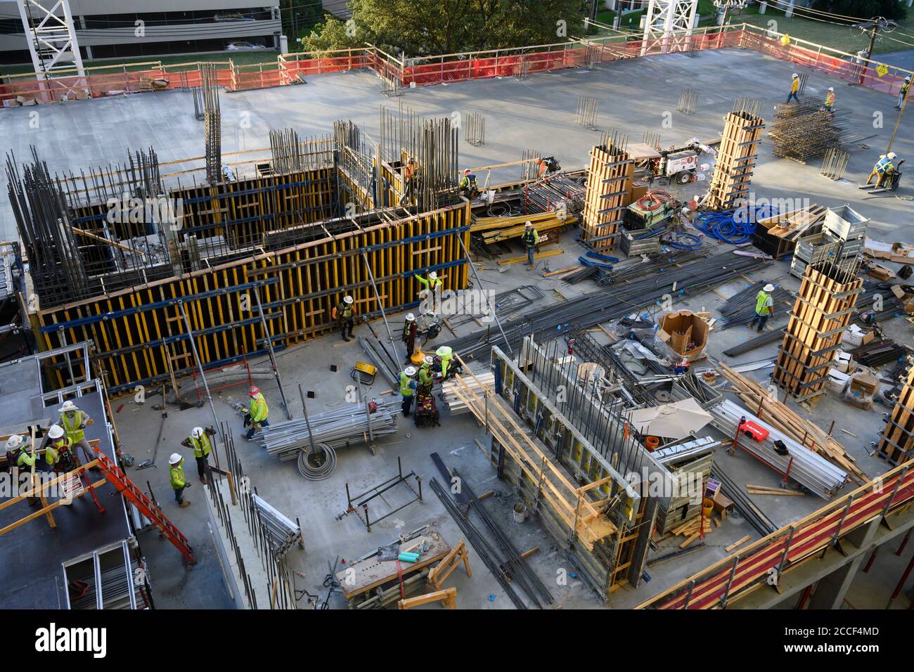 Austin, Texas, USA. Juli 2020. Betonbesatzungen arbeiten in der Parkgarage eines 53-stöckigen Gebäudes während eines nächtlichen Gefalles im Rainey Street District in der Innenstadt von Austin. Trotz dreistelliger Tagestemperaturen und steigender COVID-19-Zahlen bleiben die Bauprojekte in Texas unbehellig. Trotz umfangreicher Vorkehrungen sind die Baumannschaften weiterhin besonders gefährdet. Quelle: Bob Daemmrich/ZUMA Wire/Alamy Live News Stockfoto