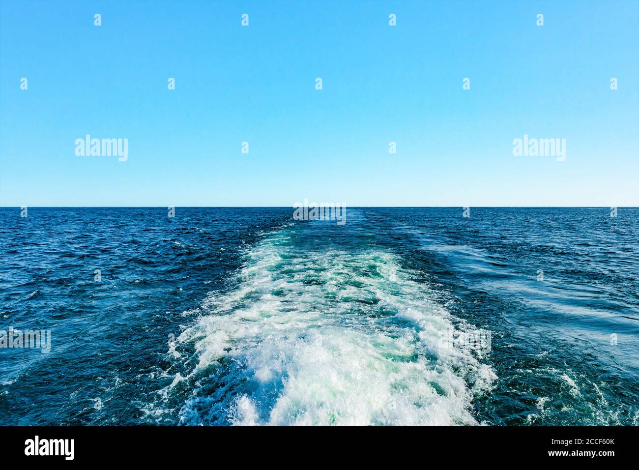 Wake eines Schiffes in blauem Wasser Stockfoto