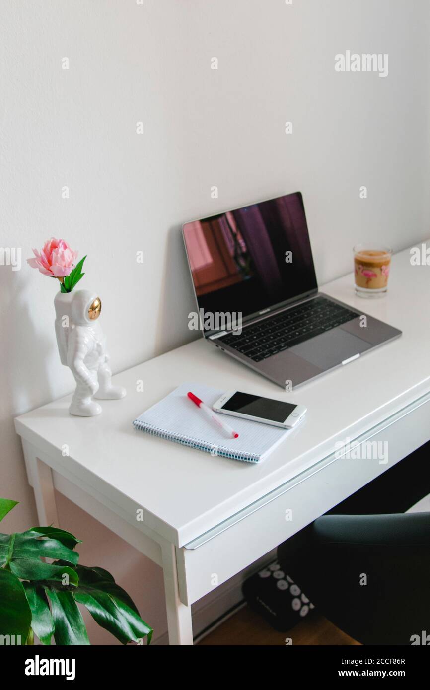 Home Office Schreibtisch mit Smartphone und dekorativer Astronaut Stockfoto