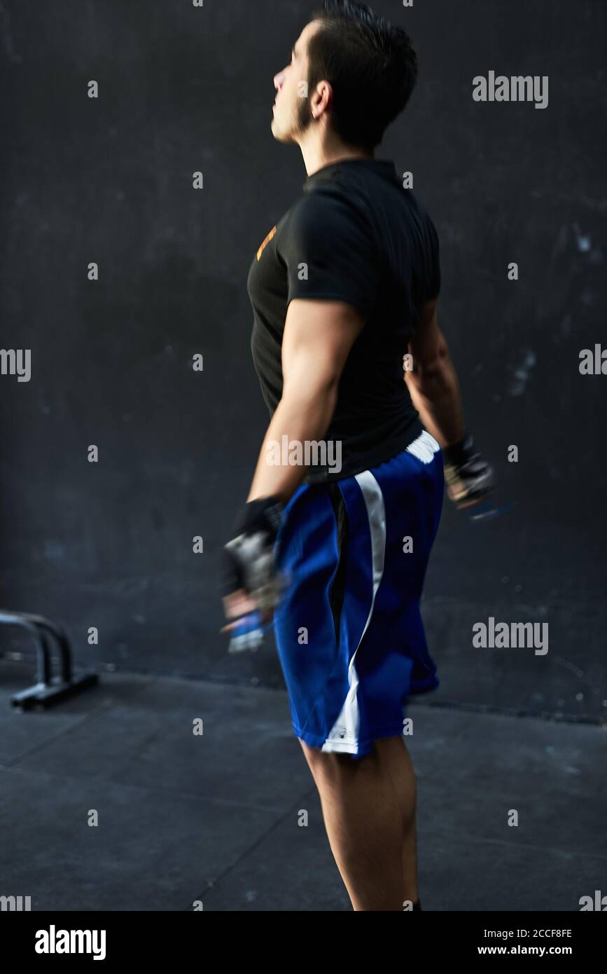 Junger Mann, der drinnen mit einem springseil ausarbeitet Fitnessraum Stockfoto