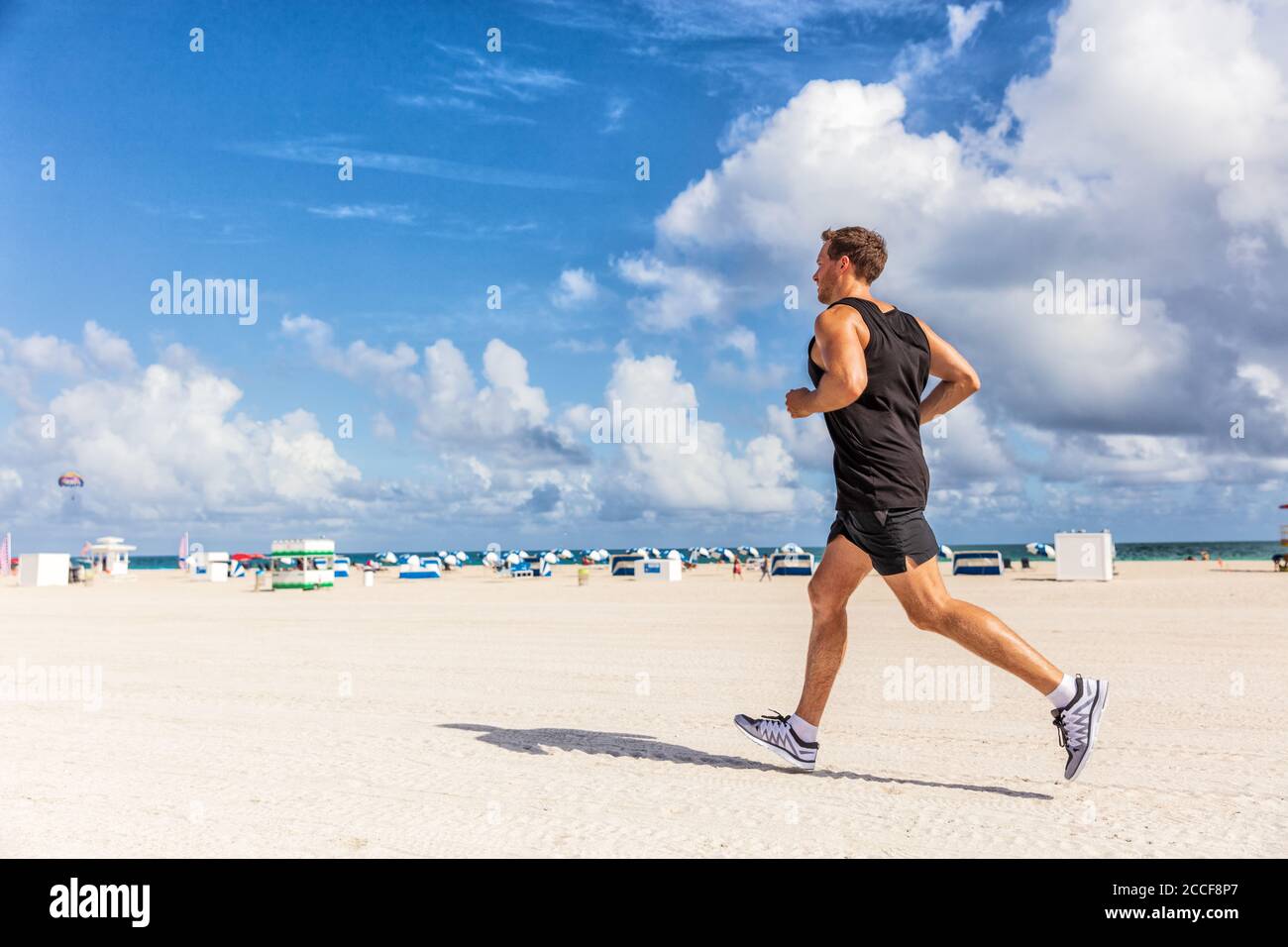 Fit Mann Laufen Joggen Training auf South Beach, Miami, Florida am Strand. Laufsportler trainieren gesunden aktiven sportlichen Lebensstil im Freien Stockfoto