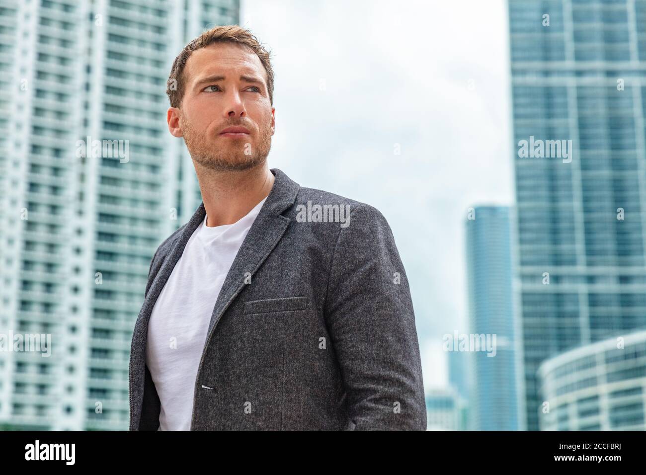 Geschäftsmann junge Mann ernst Porträt tragen smart casual Blazer im Freien Im Hintergrund der Hochhäuser der Stadt Stockfoto