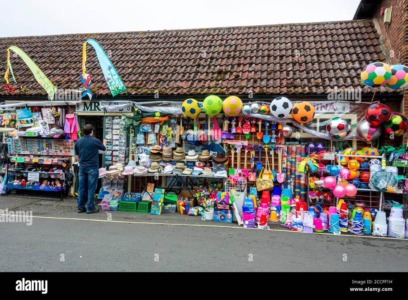 Ein traditionelles englisches Spielzeuggeschäft am Meer mit Strandspielzeug, Eimern, Spaten und Strandbällen zum Verkauf für den Strand in Wells-next-the-Sea in Norfolk, Großbritannien, Stockfoto