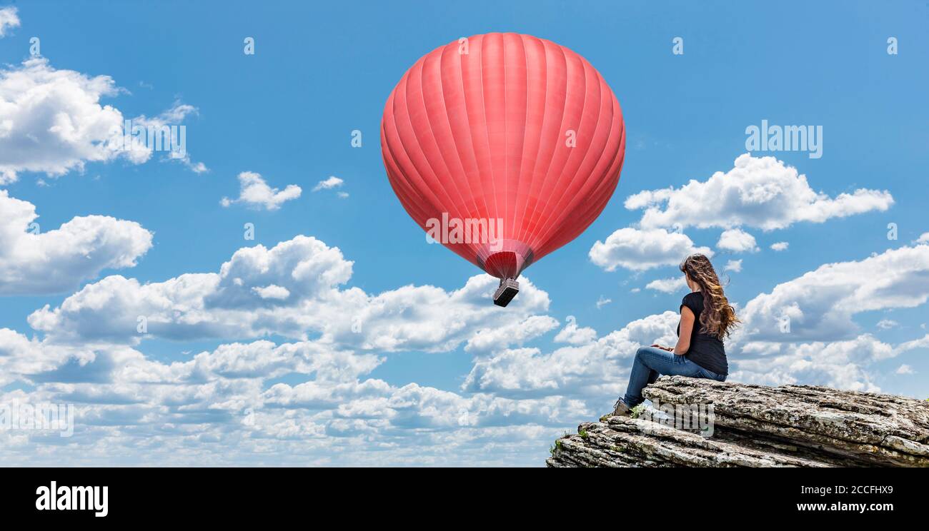 Frau auf Klippe mit Heißluftballon Stockfoto