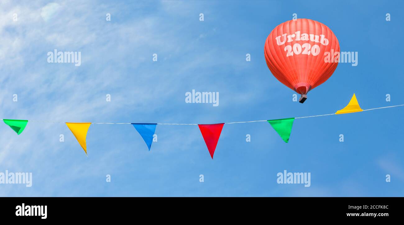 Heißluftballon, symbolisches Bild Urlaub 2020 mit farbigen Fahnen Stockfoto