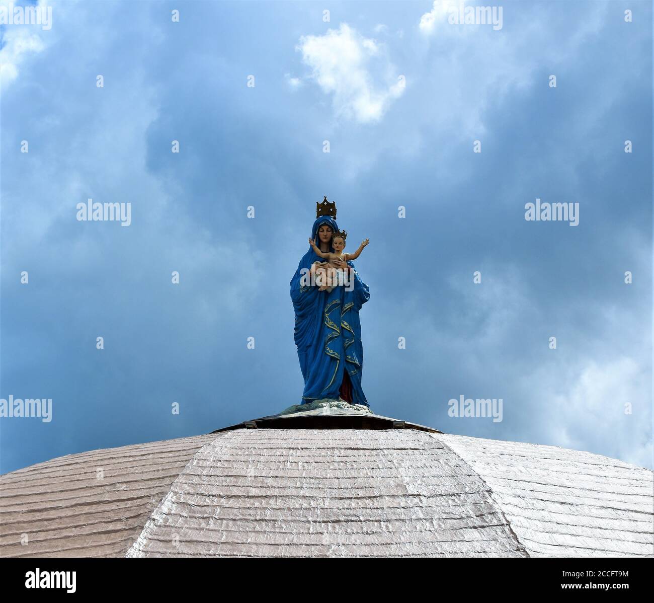Eine Statue der Jungfrau Maria, die das Baby trägt Jesus steht auf einer weißen Kuppel eines kirche Stockfoto