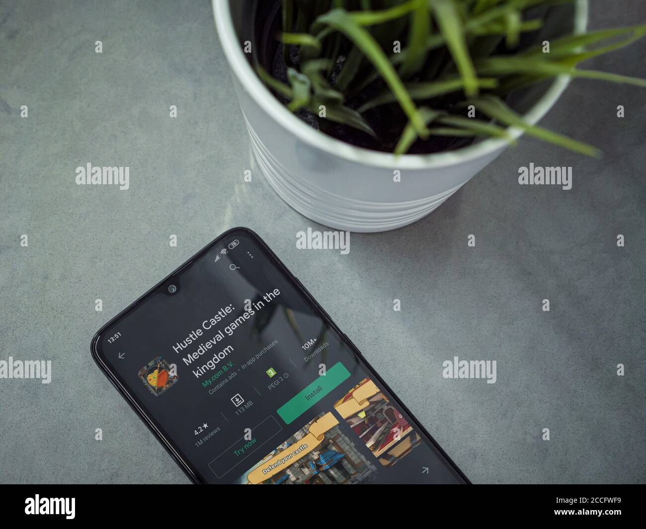 LOD, Israel - 8. Juli 2020: Moderner minimalistischer Büroarbeitsplatz mit schwarzem Smartphone mit Hustle Castle App Play Store Seite auf Marmor Backgroun Stockfoto