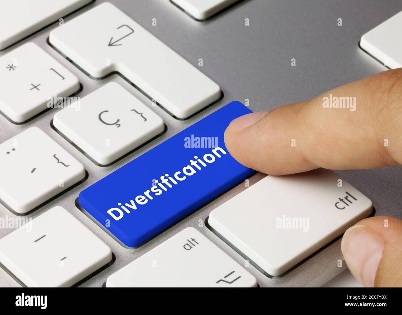 Diversifikation geschrieben auf Blue Key der metallischen Tastatur. Drücken Sie die Taste mit dem Finger. Stockfoto