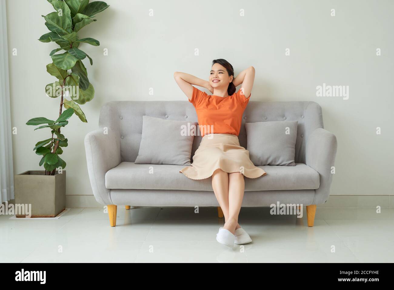 Vorne voller Länge Blick ruhige Millennial hübsche Frau entspannen auf einem bequemen Sofa im Wohnzimmer. Stockfoto