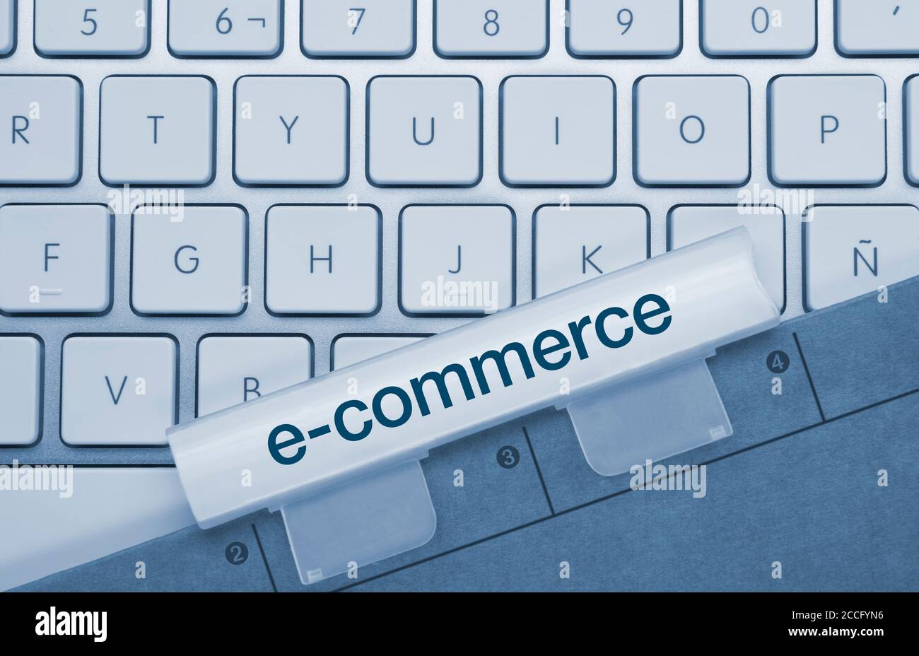 E-Commerce geschrieben auf Blue Key von Metallic Keyboard. Drücken Sie die Taste mit dem Finger. Stockfoto