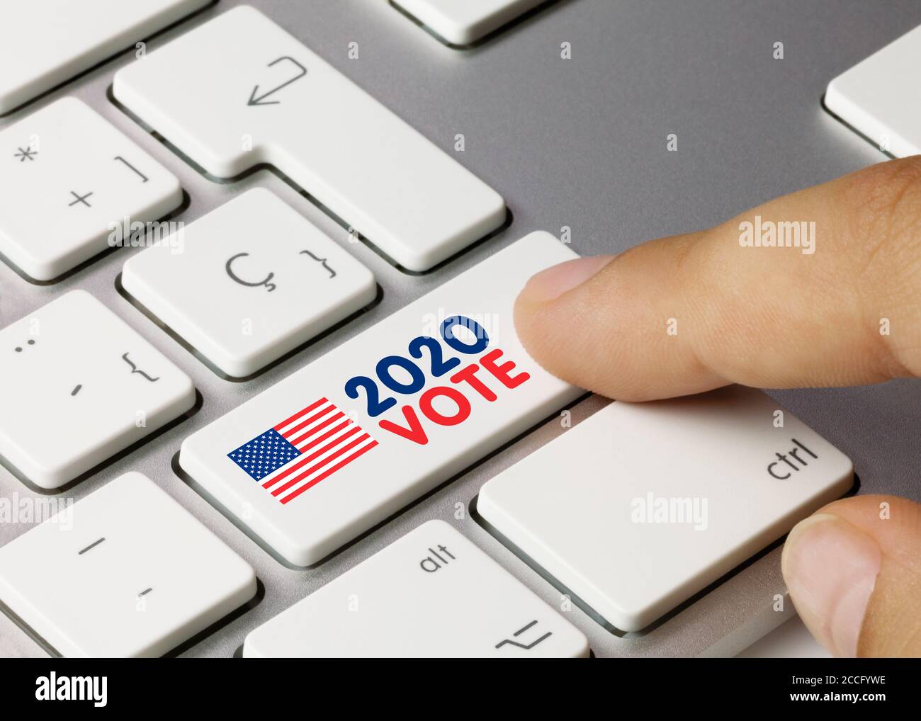 EEUU 2020 STIMME geschrieben auf White Key der metallischen Tastatur. Drücken Sie die Taste mit dem Finger. Stockfoto