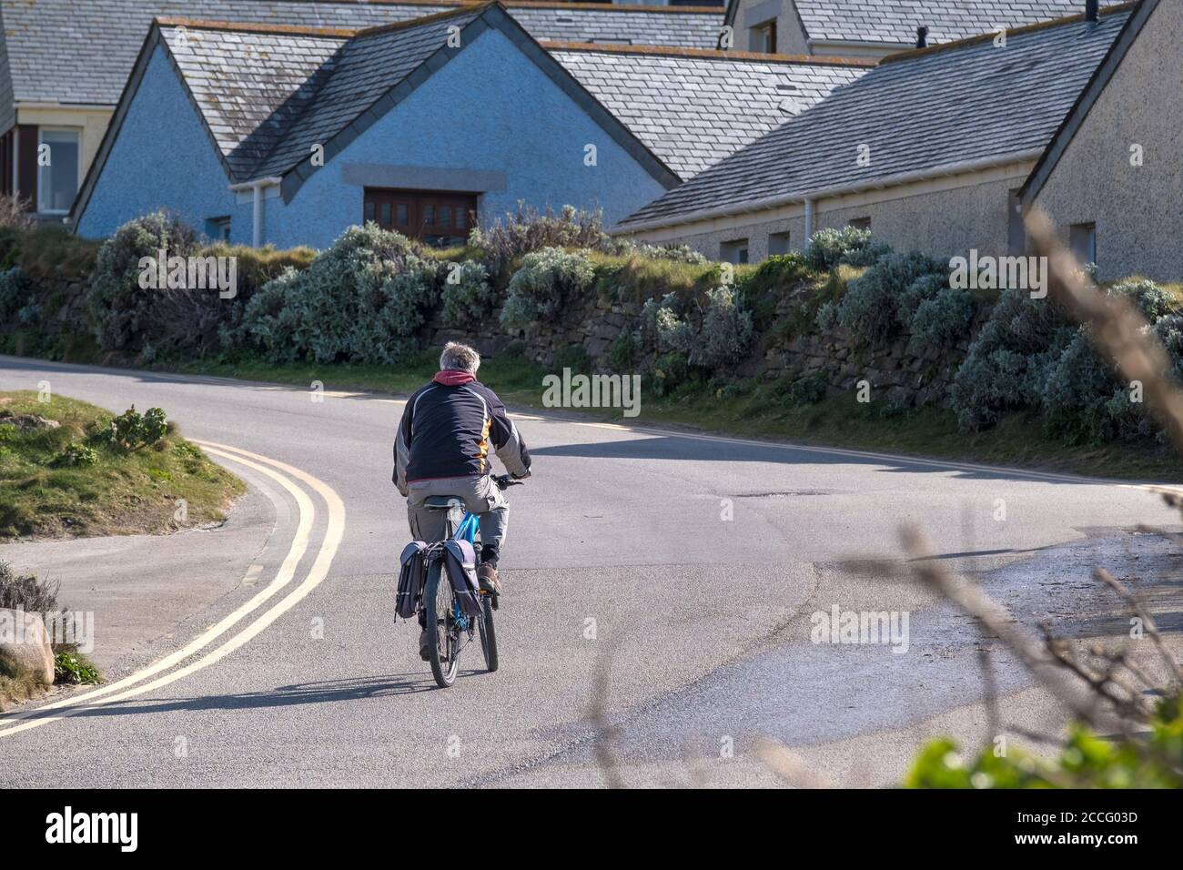 Ein Mann, der in Newquay in Cornwall bergauf radelt. Stockfoto