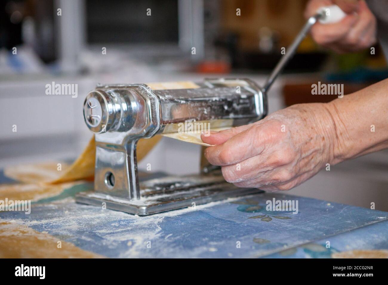 In der Küche, Zubereitung von hausgemachten Nudeln mit Pasta-Maschine. Stockfoto