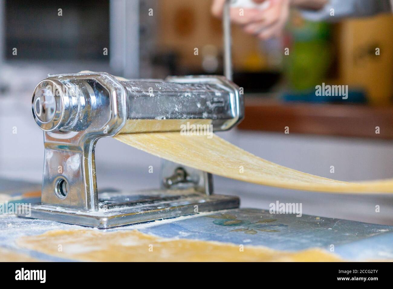 In der Küche, Zubereitung von hausgemachten Nudeln mit Pasta-Maschine. Stockfoto