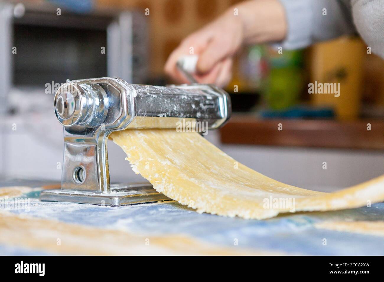 In der Küche, Zubereitung von hausgemachten Nudeln mit Pasta-Maschine. Stockfoto