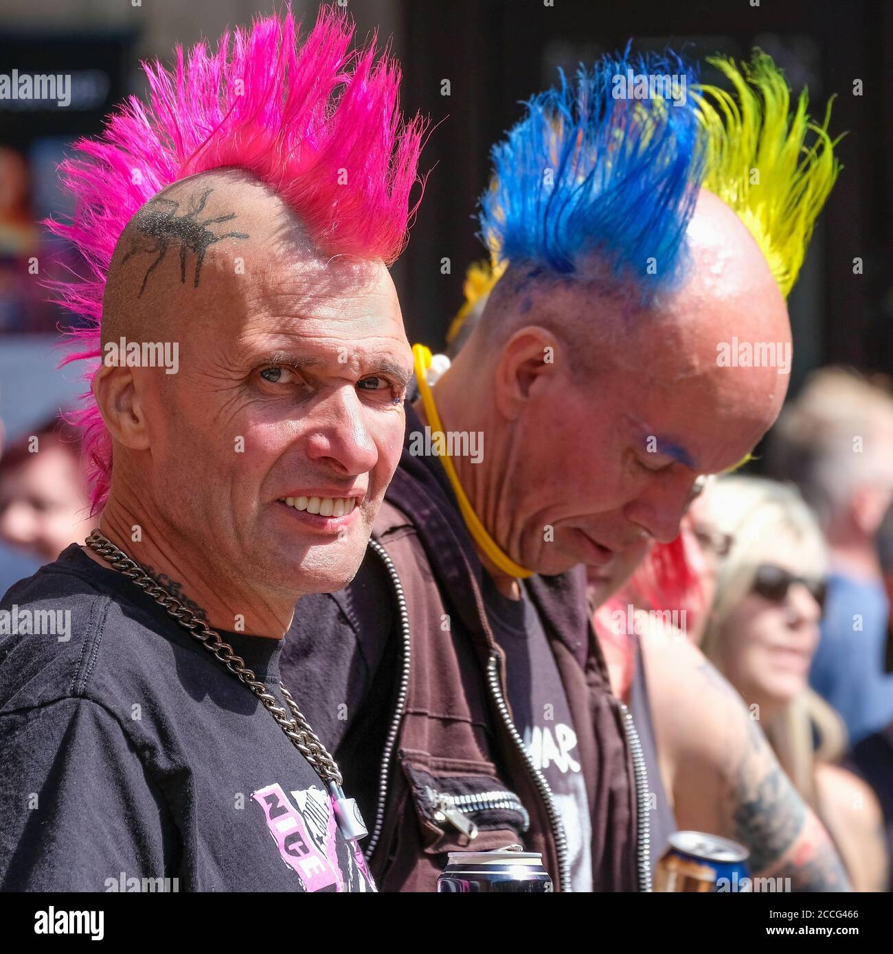 Ein Paar mittelalter Punk-Männer mit lebhaften mohican-Haarschnitten in Blau, Gelb und Pink Stockfoto
