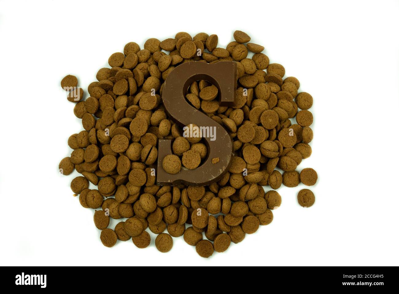 Traditionelle holländische gebackene Pepernoten auf weißem Hintergrund mit einem Schokoladenbuchstaben in der Mitte. Leckereien, die Kinder mit sint Nicolas gegeben werden Stockfoto