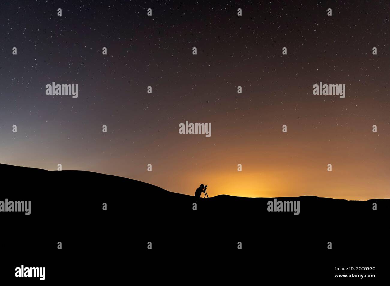 Silhouette des Fotografen, der Bilder vom Nachthimmel fotografiert Stockfoto