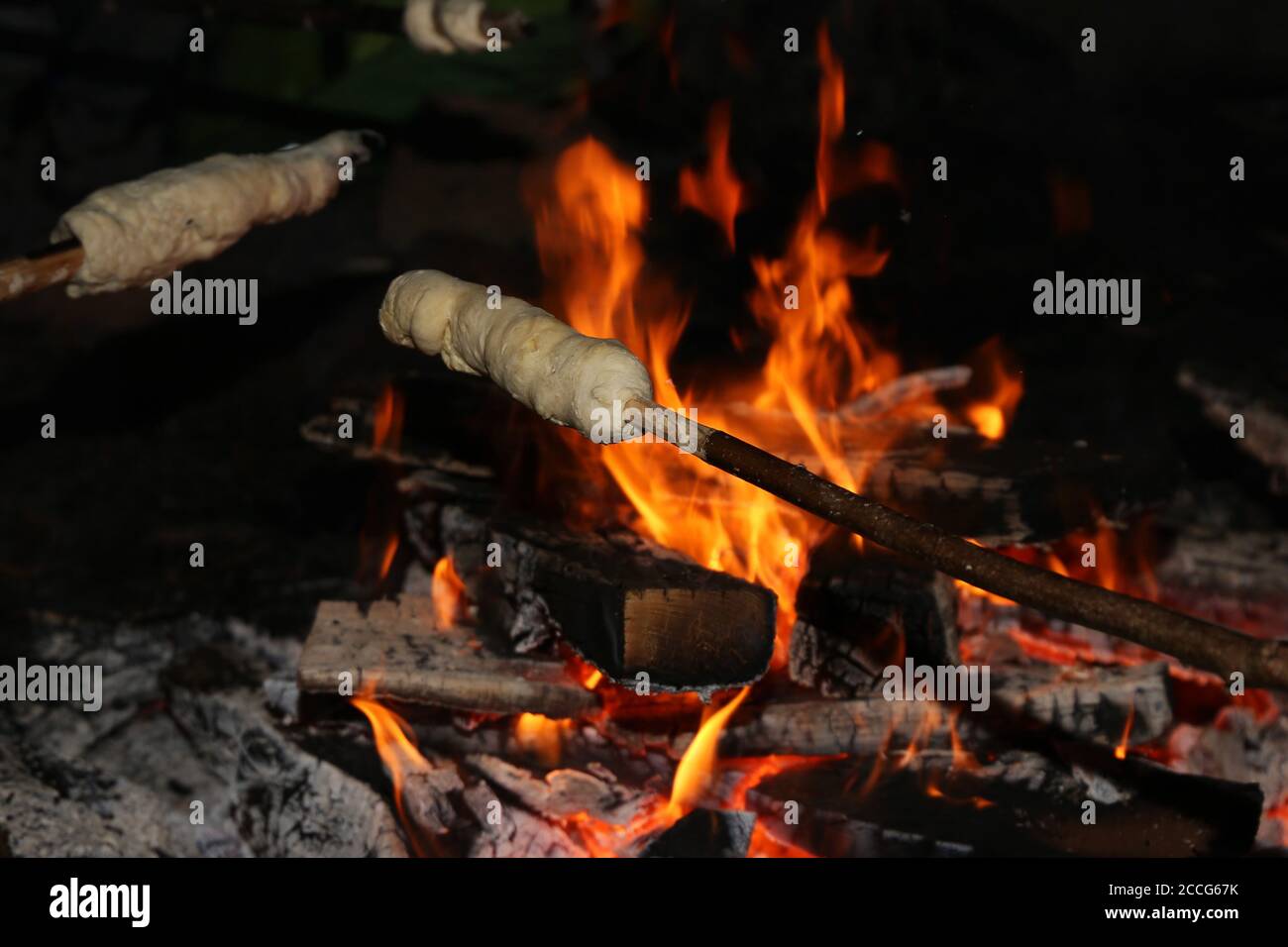 Backen von Stockbrot auf dem Lagerfeuer Stockfoto