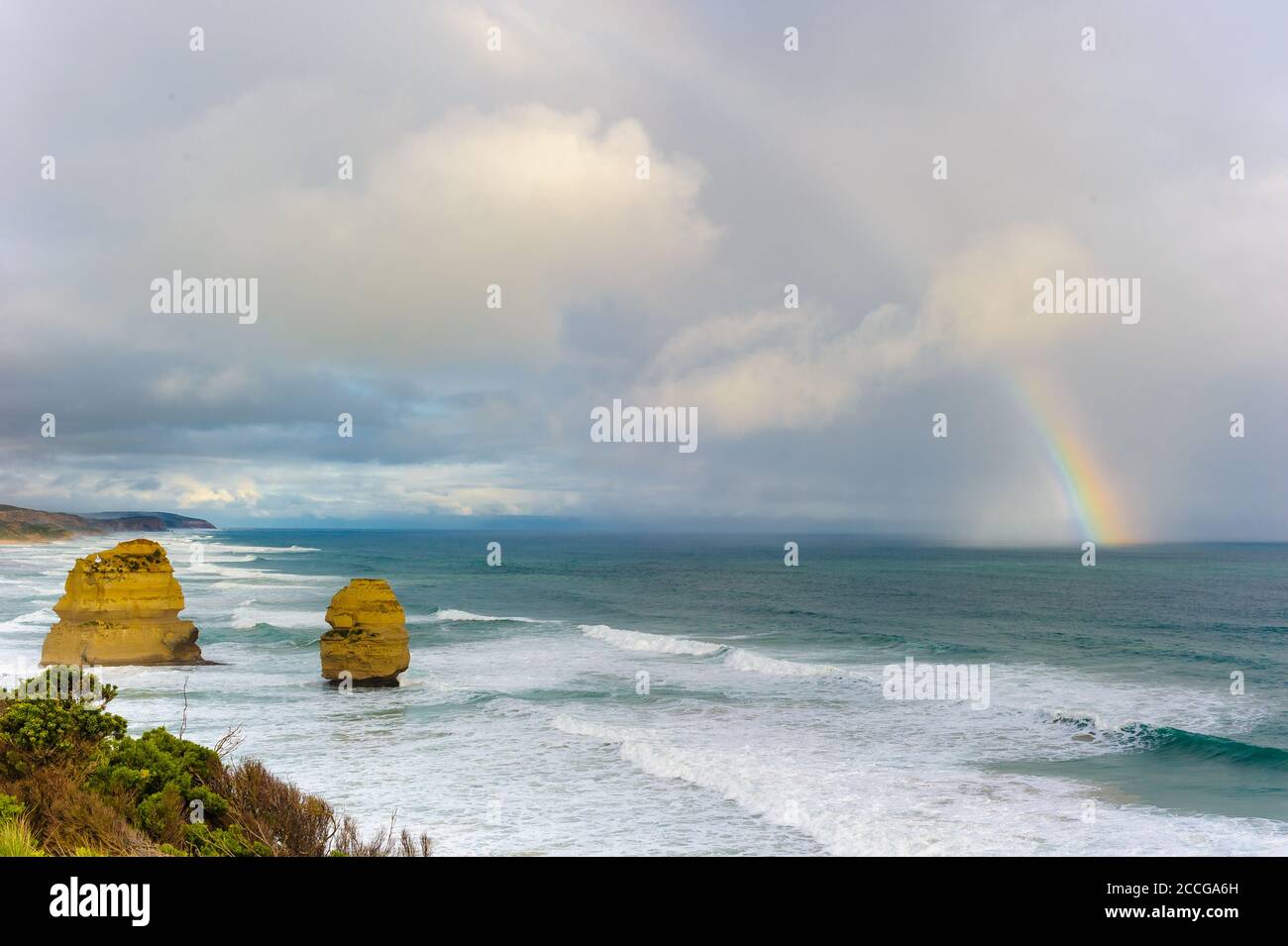 Zwei verbleibende Stapel und Regenbogen umarmen die Felswand an der wilden, östlichen Küste der Twelve Apostles an der Great Ocean Road in Victoria in Australien. Stockfoto