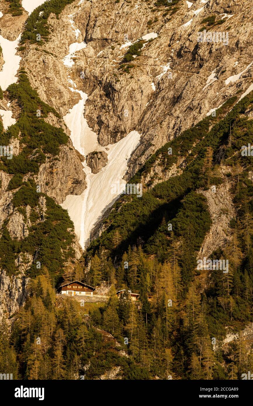Mittenwalder Hütte im warmen Abendlicht mit Schneefeld Im Hintergrund Stockfoto