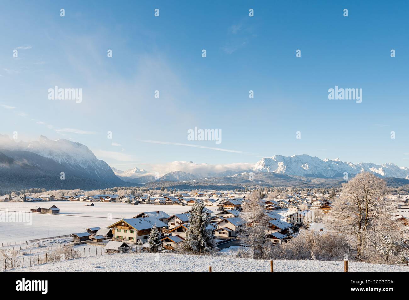 Blick auf das verschneite Dorf Wallgau im Bayerischen Alpen im Winter mit frischem Schnee und einem blauen Himmel Stockfoto