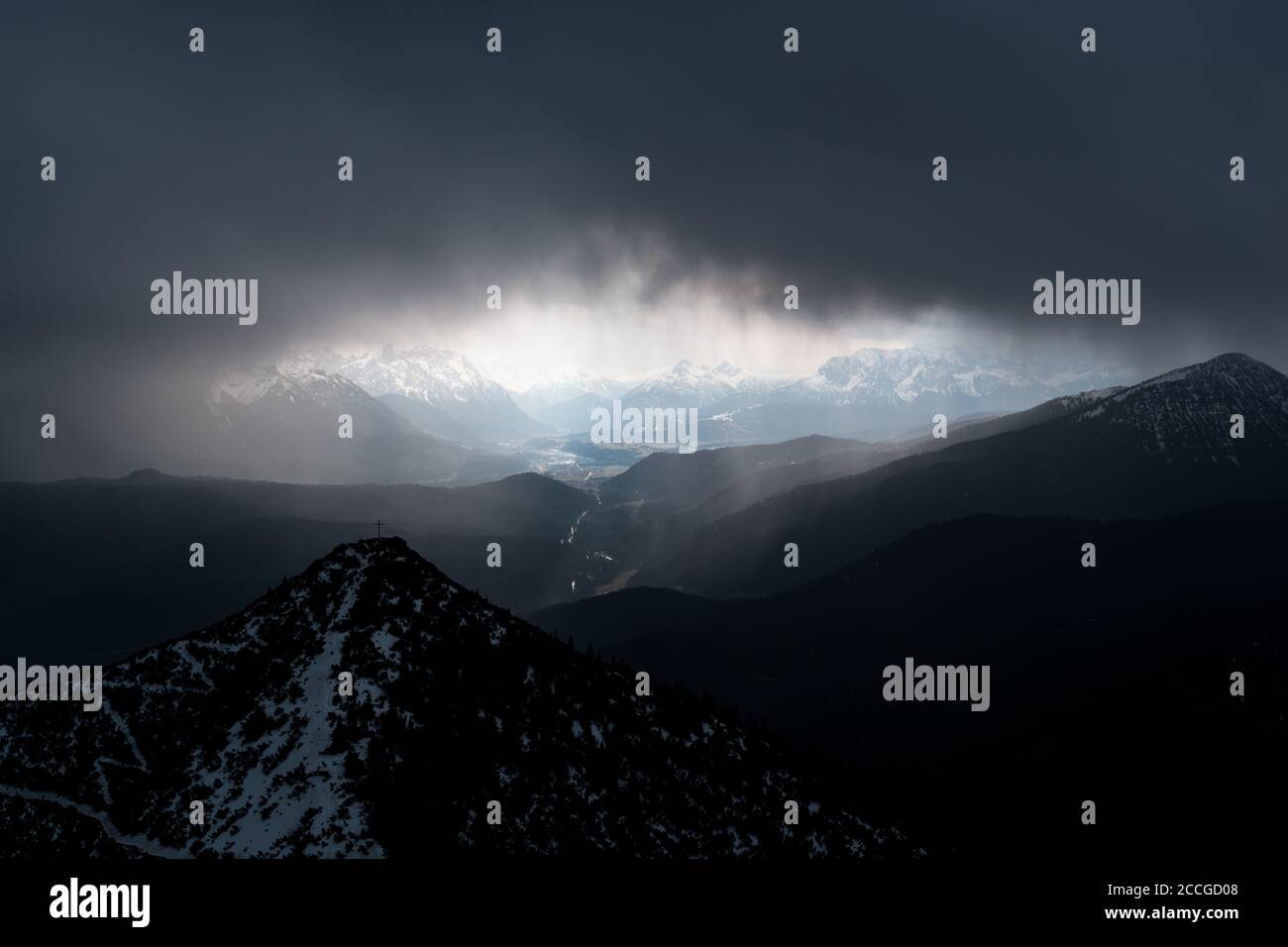 Martinskopf neben dem Herzogstand bei schlechtem Wetter. Dicke Wolken und ein paar Schneestücke unterstreichen das dunkle und wilde Gebirge. Ein dunkler Sturm c Stockfoto