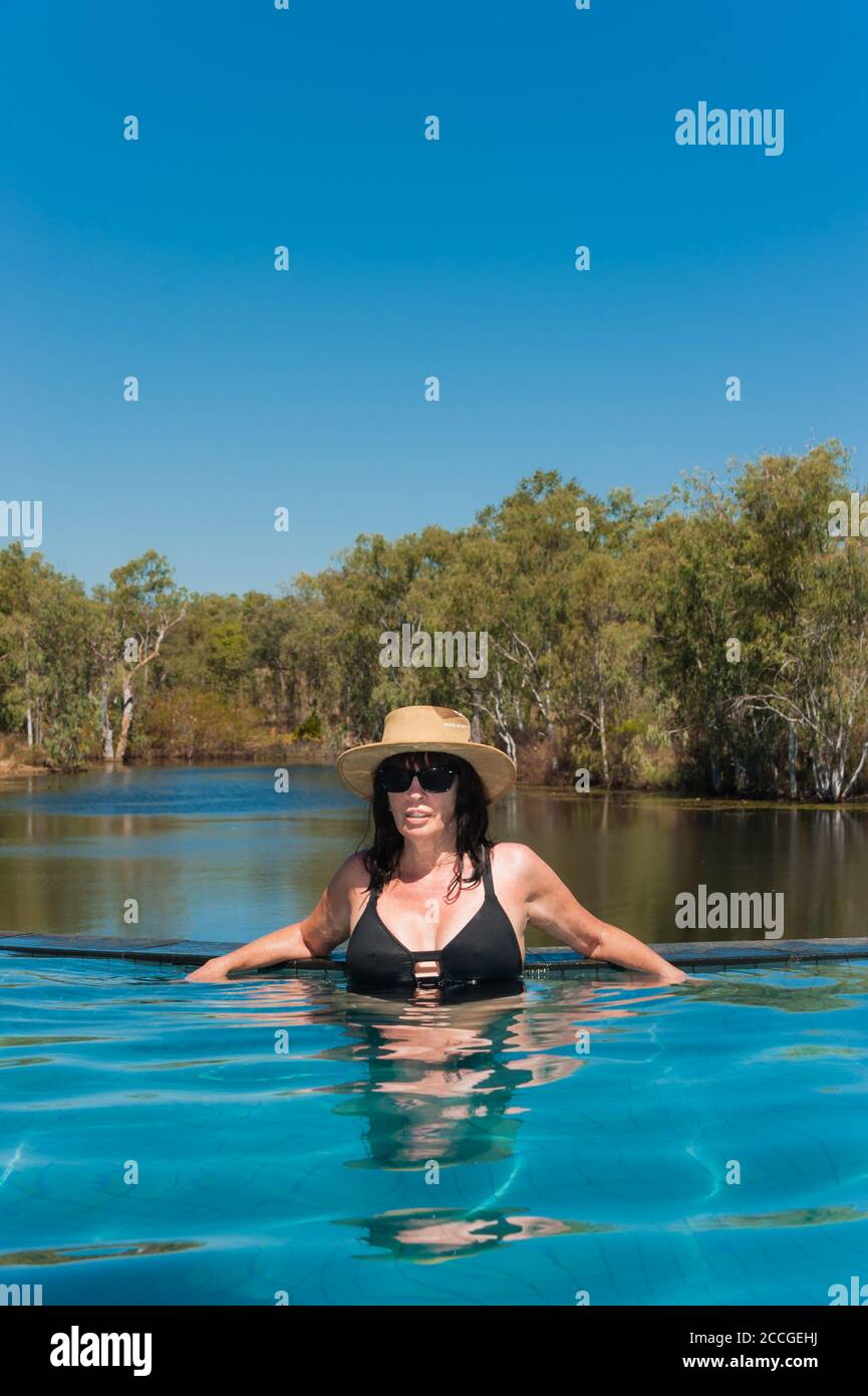 Eine wunderschöne weibliche Touristin, die im Outback Australien unterwegs ist, kühlt sich in einem Infinity-Pool in der Cobbold Gorge im Westen von Queensland ab. Stockfoto