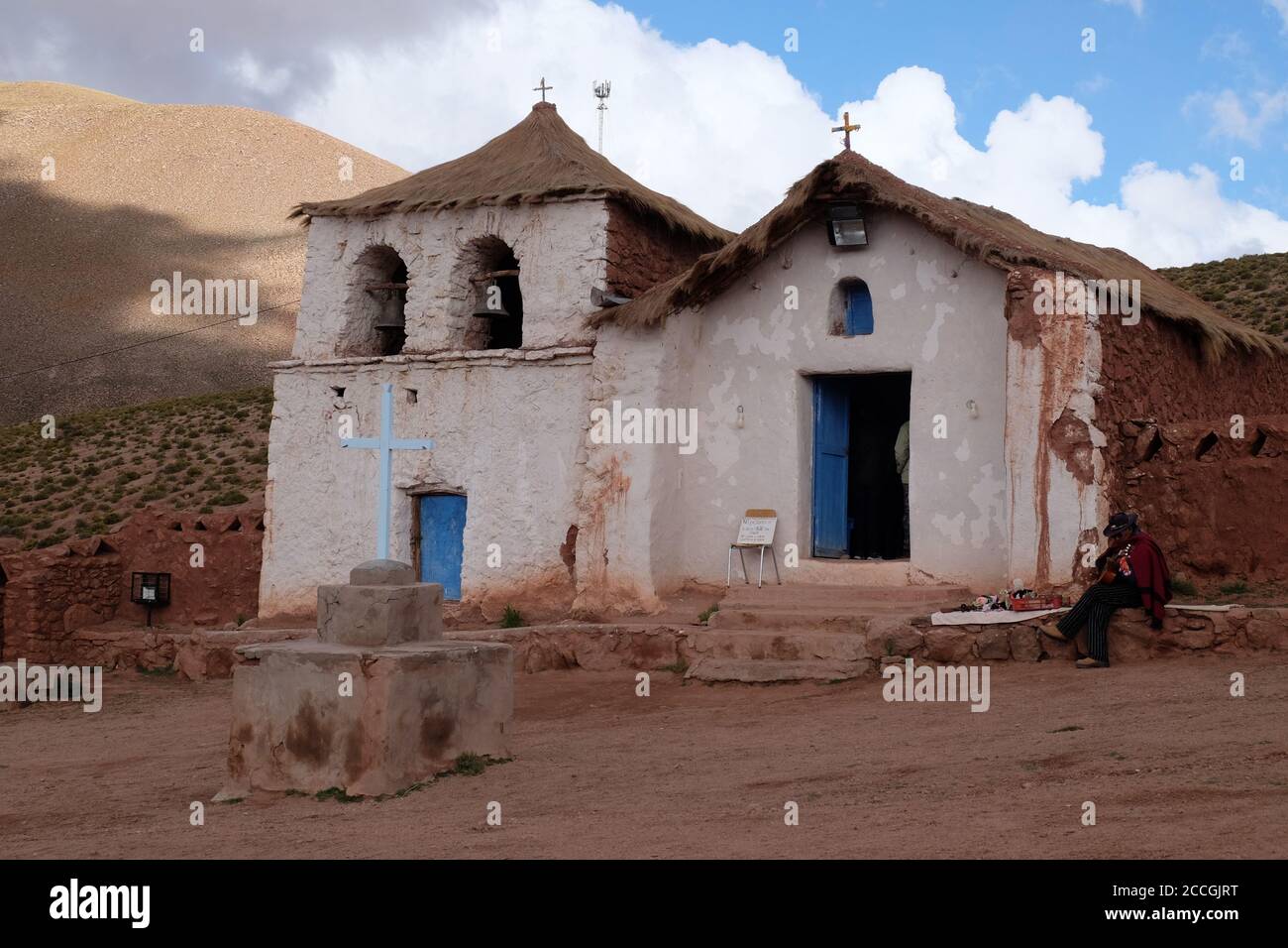 Der andindische Musiker unterhält Touristen, die die kleine Kirche von Machuca hoch in den chilenischen anden besuchen. Stockfoto