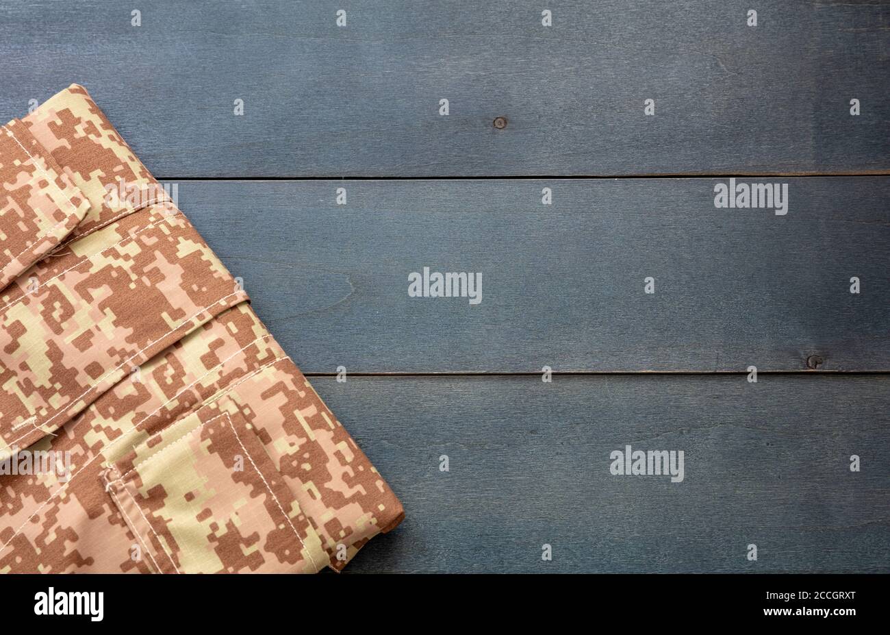US Army acu Digital Desert Uniform Shirt auf blauem Holzhintergrund. Militär Camouflage digitale Wüste Muster gefaltet Hemd Detail, kopieren Raum, templa Stockfoto