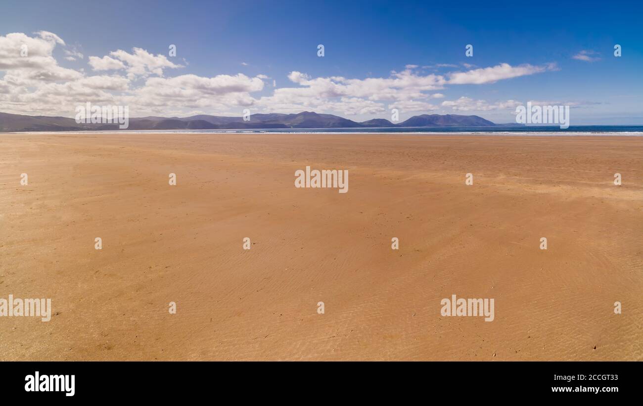 Langer, schöner Sandstrand Inch Beach mit Bergen im Hintergrund. Sommertag mit blauem Himmel am leeren Strand, Entspannung. Dingle Peninsula, Irland Stockfoto