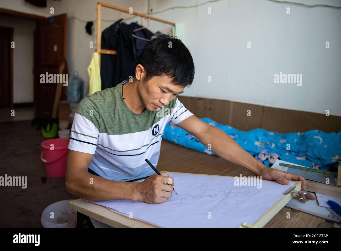 (200822) -- NINGXIANG, 22. August 2020 (Xinhua) -- Xiao Ming praktiziert Skizze in seinem Schlafsaal einer Fabrik in der Stadt Ningxiang, der Provinz Hunan in Zentralchina, 20. August 2020. Xiao Ming, 40, ist eine hörgeschädigte Person, die seit ihrer Kindheit gerne malt. Aber aufgrund seines schlechten Familienzustandes musste er den Pinsel absetzen, um einen anderen Weg zu finden, seinen Lebensunterhalt zu verdienen. Er fand einen Job in einer Fabrik und lernte Bienen zu zühen, durch die er ein stabiles Einkommen gewann. Nachdem Xiao 2018 die Armut abschüttelte, versuchte er, seinen Pinsel wieder aufzunehmen und seinen Traum fortzusetzen. Nun verwandelte er ein Zimmer seines Hauses in einen Pai Stockfoto