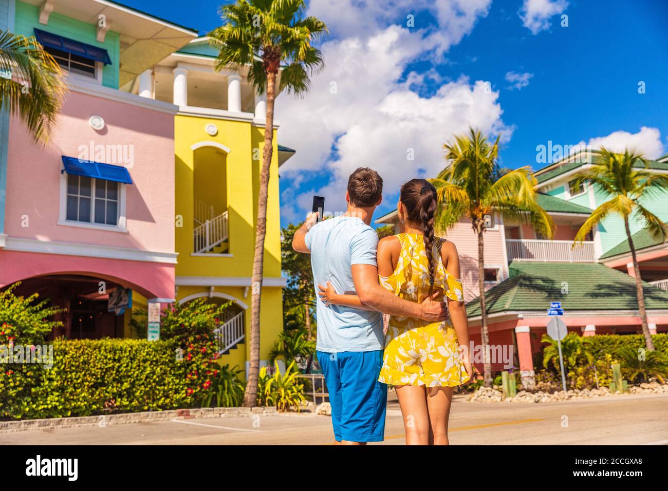 Paar im Winterurlaub machen Bilder von pastellfarbenen Strandhäusern Hütten in tropischen Urlaubsziel Fort Myers, Florida. Mann Tourist Stockfoto