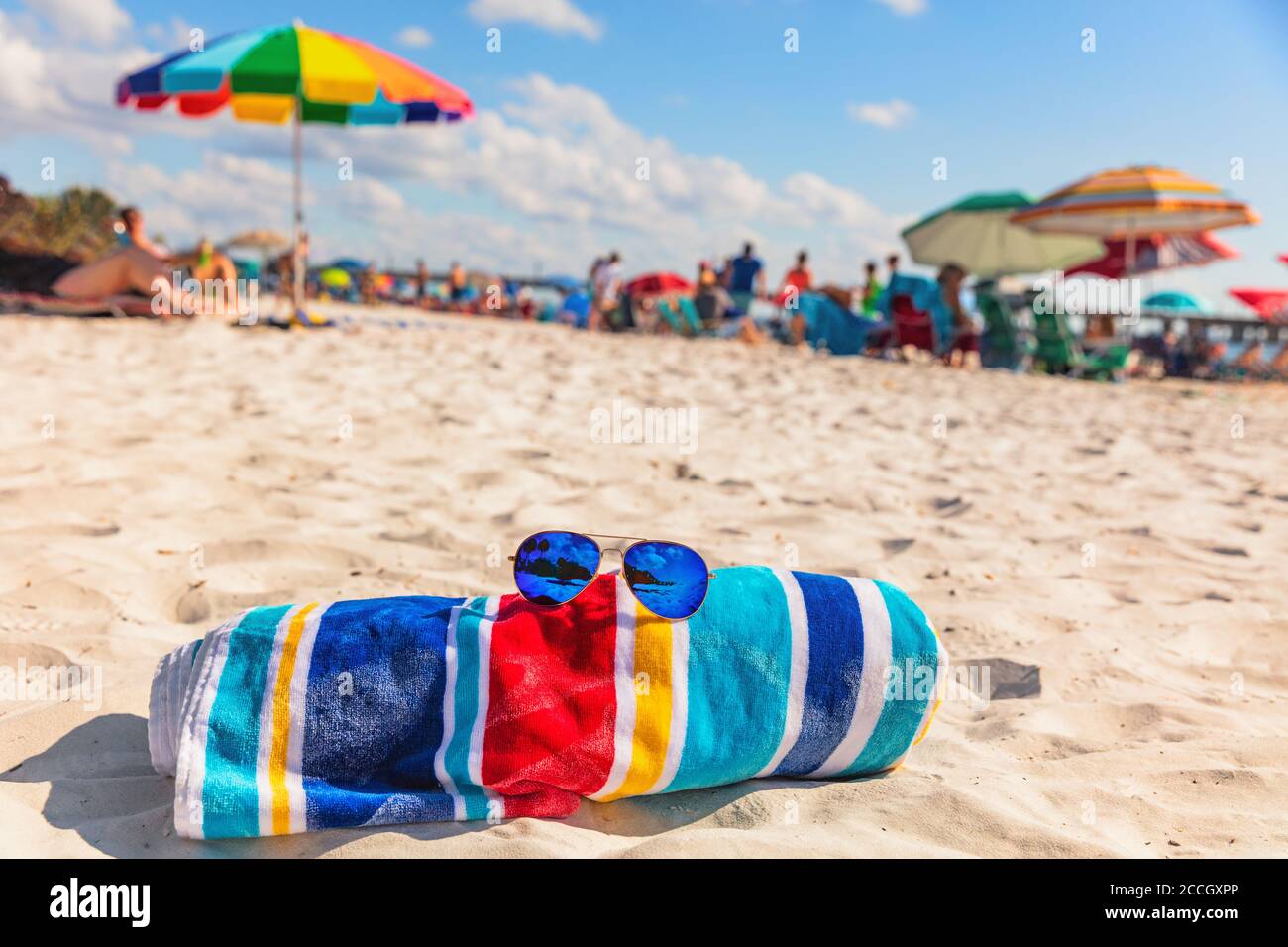Strandtuch und Mode Sonnenbrille auf Florida Strand Hintergrund -Sommer Urlaub Reise Konzept kopieren Raum. Überfüllt beliebte USA Ziel für Stockfoto