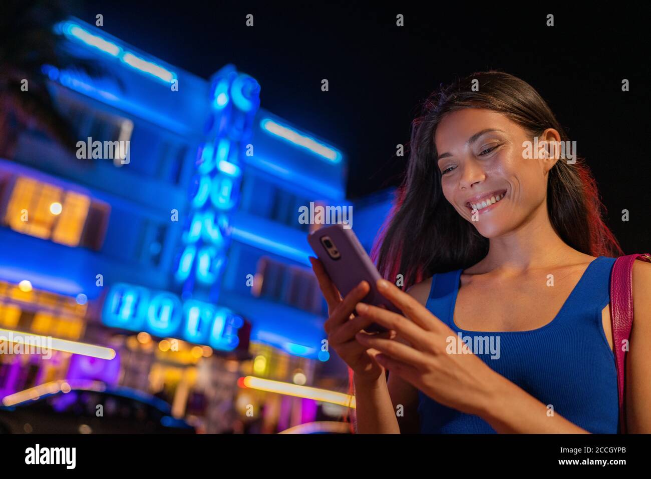 Miami Frau SMS Telefon zu Fuß auf Ocean Drive South Beach FLORIDA, USA. Art Deco Hotels und Restaurants in der Nacht weltberühmten Touristenziel Stockfoto