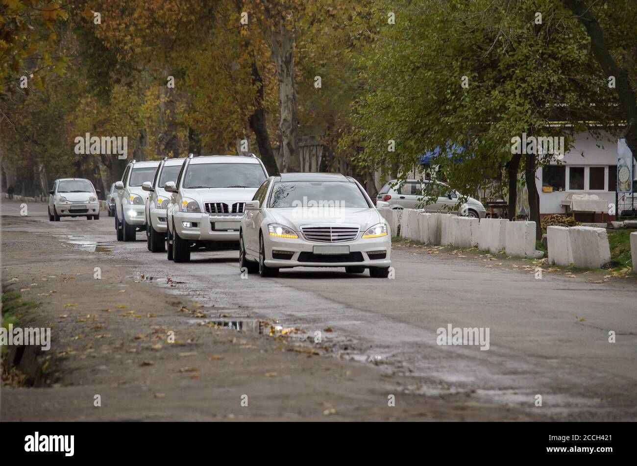 Fünf Autos, Autokolonne, auf der Straße in der Stadt im Herbst Stockfoto