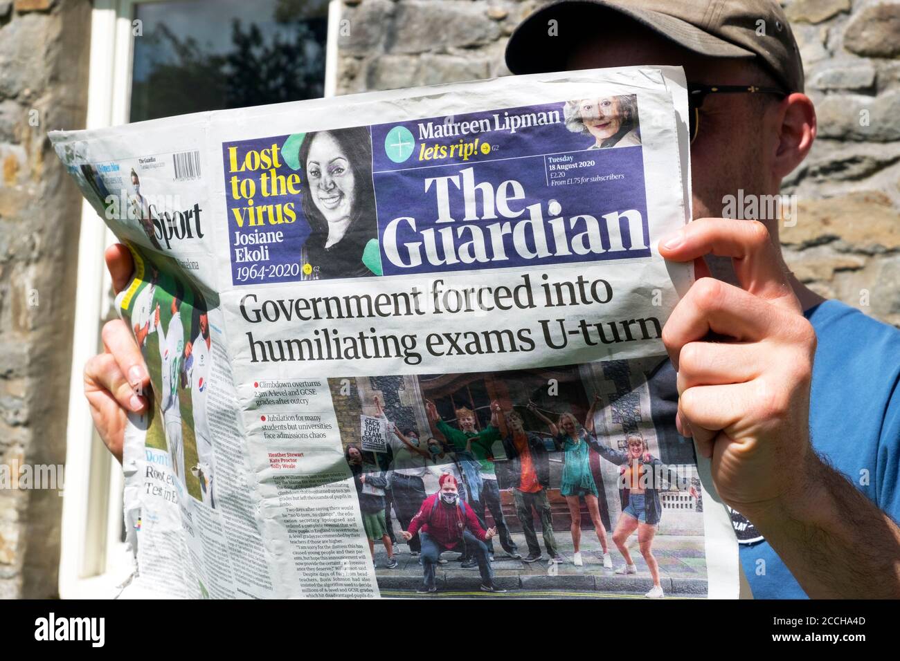 "Regierung gezwungen, zu demütigenden Prüfungen U-Turn" junger Mann Student Lesen Guardian Zeitung Schlagzeile August 2020 London England Großbritannien Stockfoto