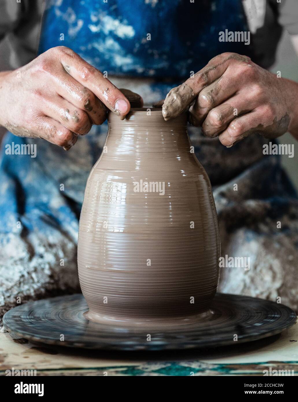 Töpferhandwerk in Ton auf Töpferscheibe. Potter macht auf dem Töpferrad Stockfoto