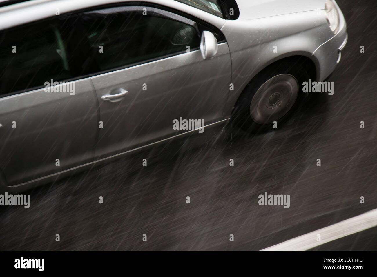 Verschwommenes Auto auf der Straße vom starken Regen mit Hagel getroffen, an einem regnerischen Tag in Bewegung verschwommen Schwenken von oben geschossen Stockfoto