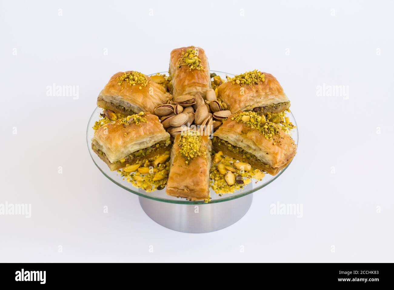 Traditionelle türkische Konditorei Dessert Baklava auf Glasplatte mit Metall Halter auf weiß.Selektiver Fokus Stockfoto