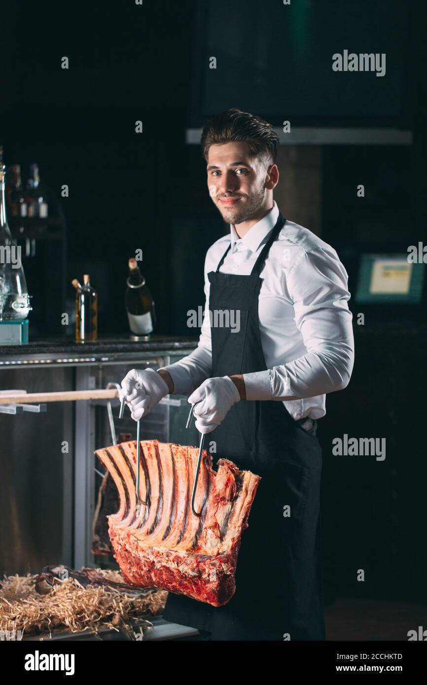 Der Kellner oder Koch bekommt trockenes Fleisch im Kühlschrank. Stockfoto