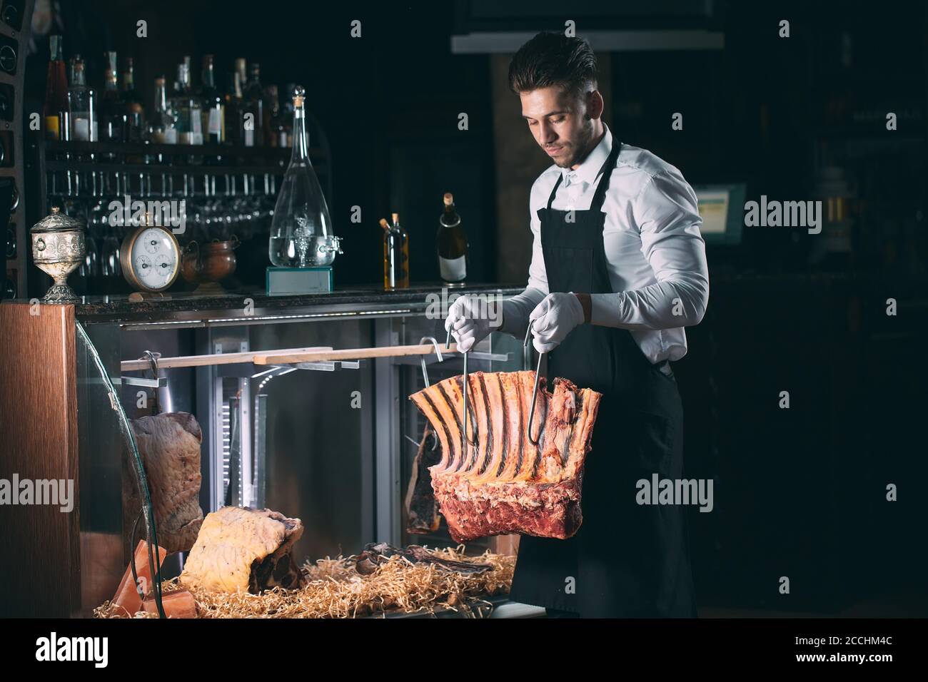Der Kellner oder Koch bekommt trockenes Fleisch im Kühlschrank. Stockfoto