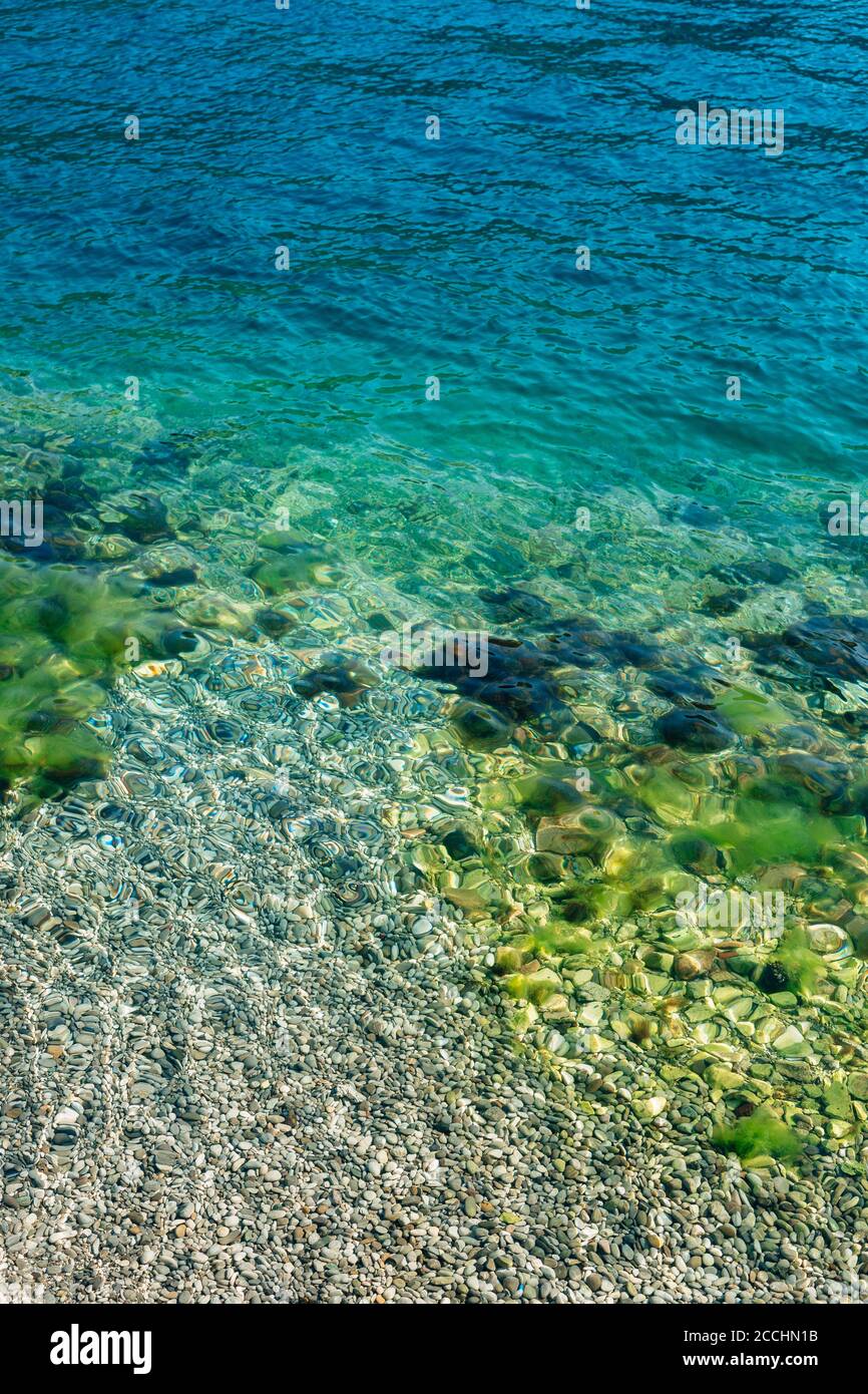 Blaues Meerwasser mit Steinen im Moos. Stockfoto