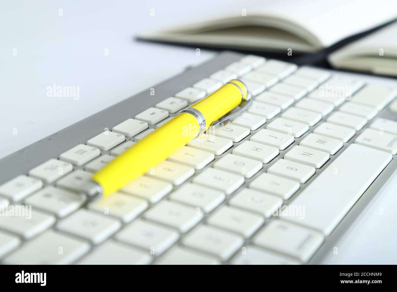 Weiße Aluminium-Tastatur mit gelbem Bürotisch Stockfoto